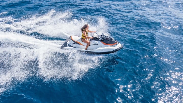 Ayoung woman riding a jet ski in the ocean