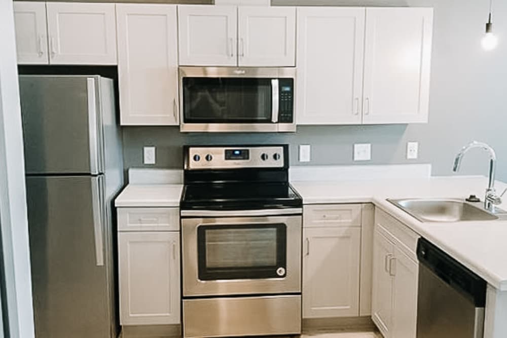 Apartment kitchen with white counters and cupboards at Leo and Alpine in Grand Rapids, Michigan
