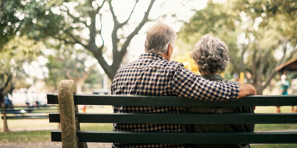 Couple sitting on a bench outside at Vista Prairie at Windmill Ponds in Alexandria, Minnesota