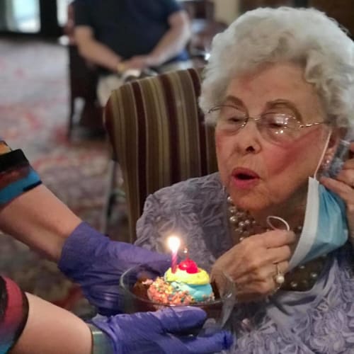 Resident blowing out a candle on a cupcake during a party at Mathison Retirement Community in Panama City, Florida