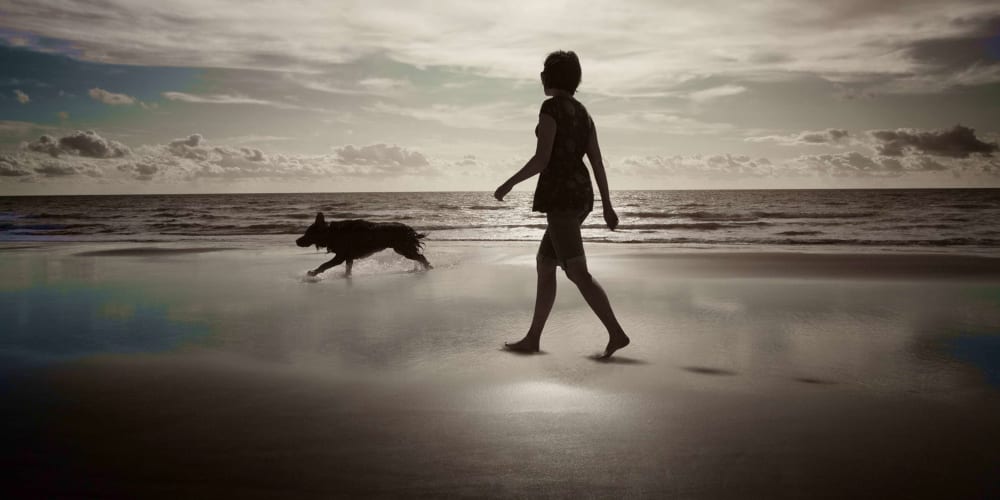 Resident on the beach with her dog at Olea Beach Haven in Jacksonville, Florida