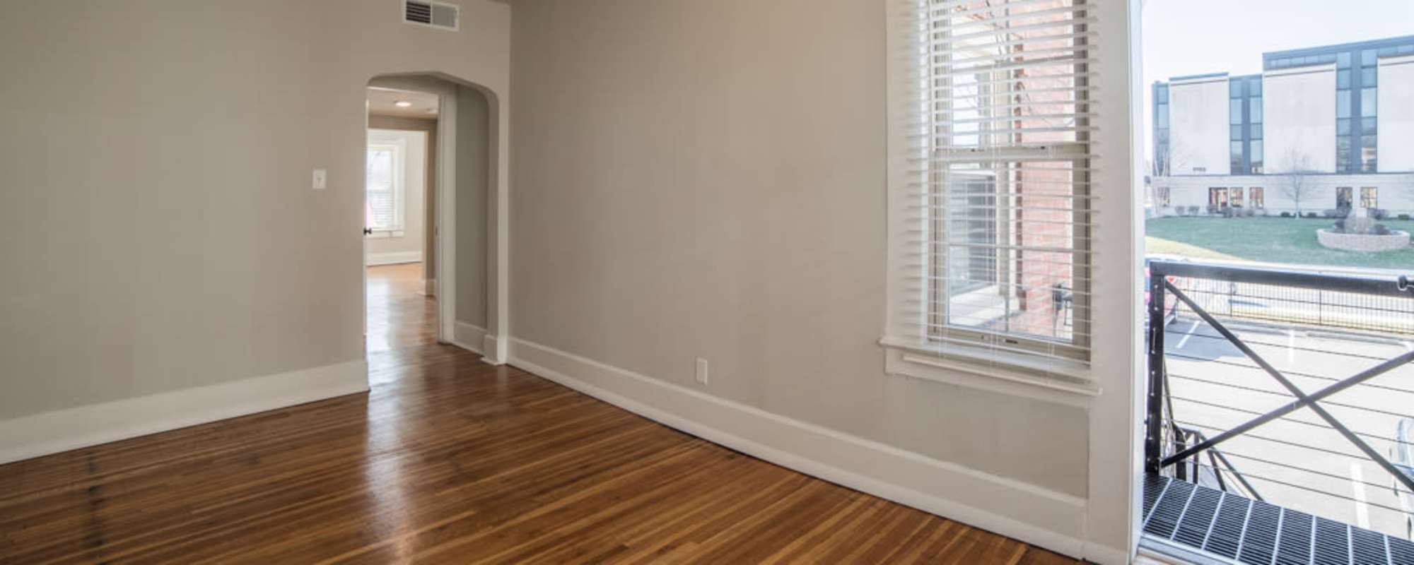 Living space with wood floors and bright windows at  Buckingham and Balmoral in Indianapolis, Indiana