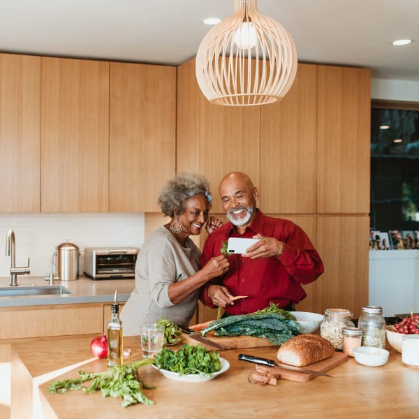 Resident couple cooking something up in the community kitchen at Pacifica Senior Living Encinitas in Encinitas, California