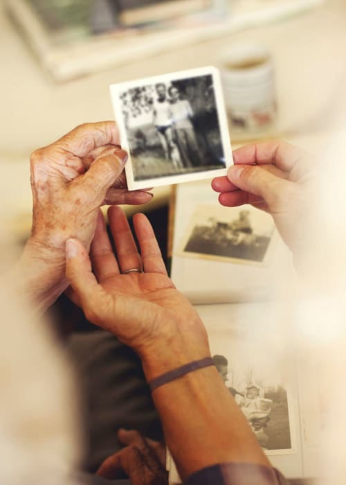 Resident looking at old photographs at Grand Villa of Delray Beach East in Delray Beach, Florida