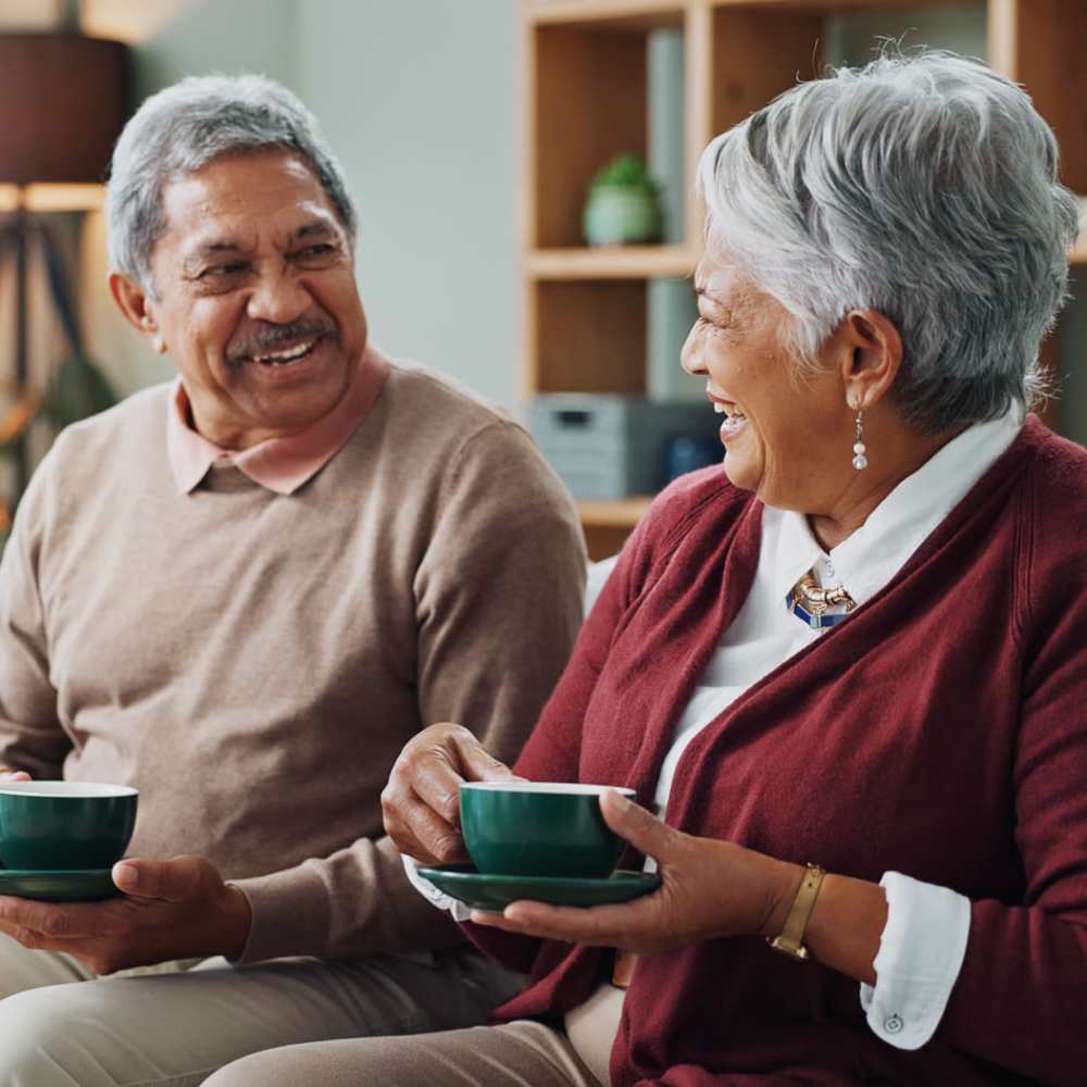 Senior resident having coffee on couch at Magnolia Place in New Port Richey, Florida