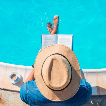 Woman reading by the pool at Adobe Lake Apartments in Concord, California
