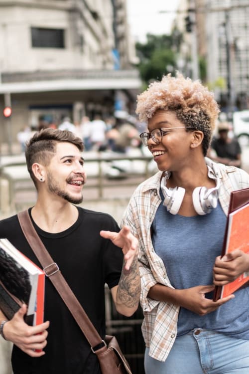 Friends walking from class to grab some food while they chat and laugh together near 1630 R St NW in Washington, District of Columbia
