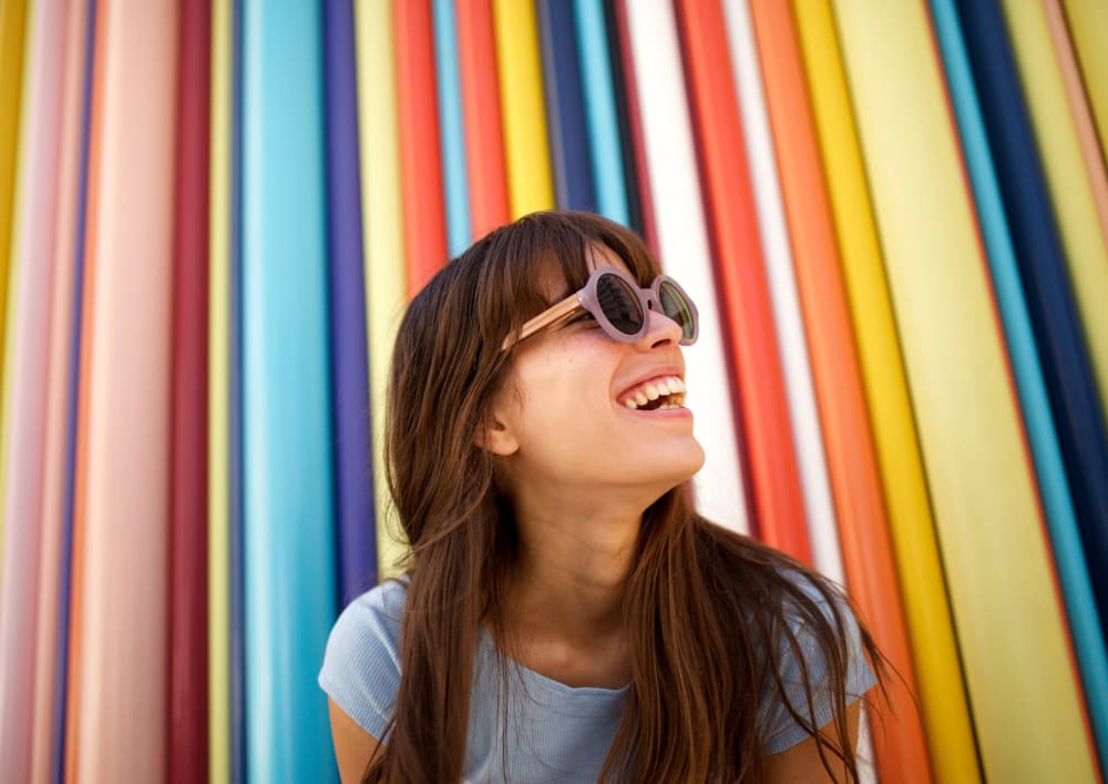 Woman smiling with colorful background wearing sunglasses at Meridian at Stanford Ranch in Rocklin, California