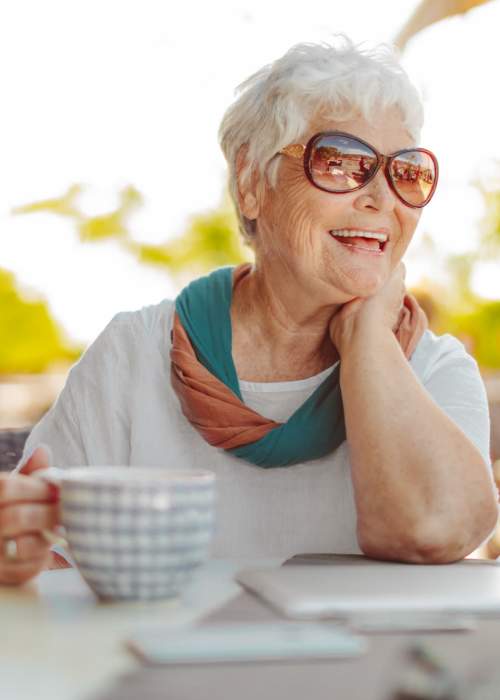 Happy resident having coffee at Grand Villa of Ocala in Ocala, Florida