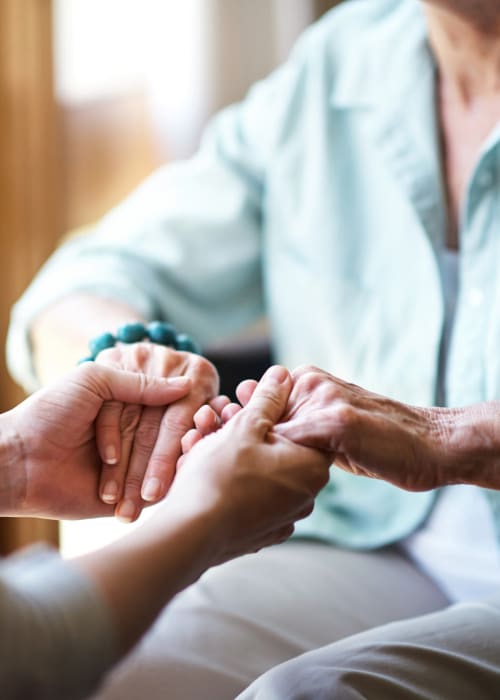 Staff member holding a resident's hands at Grand Villa of Clearwater in Clearwater, Florida
