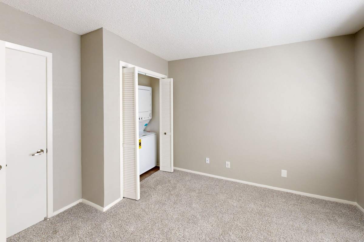 Resident bedroom with a stacked laundry at Creekside in San Angelo, Texas