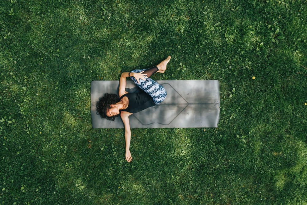 Resident doing yoga on the lawn at Bull Run Apartments in Miami Lakes, Florida
