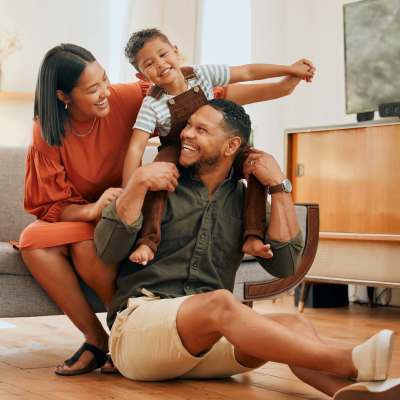 Happy family sitting on couch at The Crossroads At Downtown Boca in Boca Raton, Florida