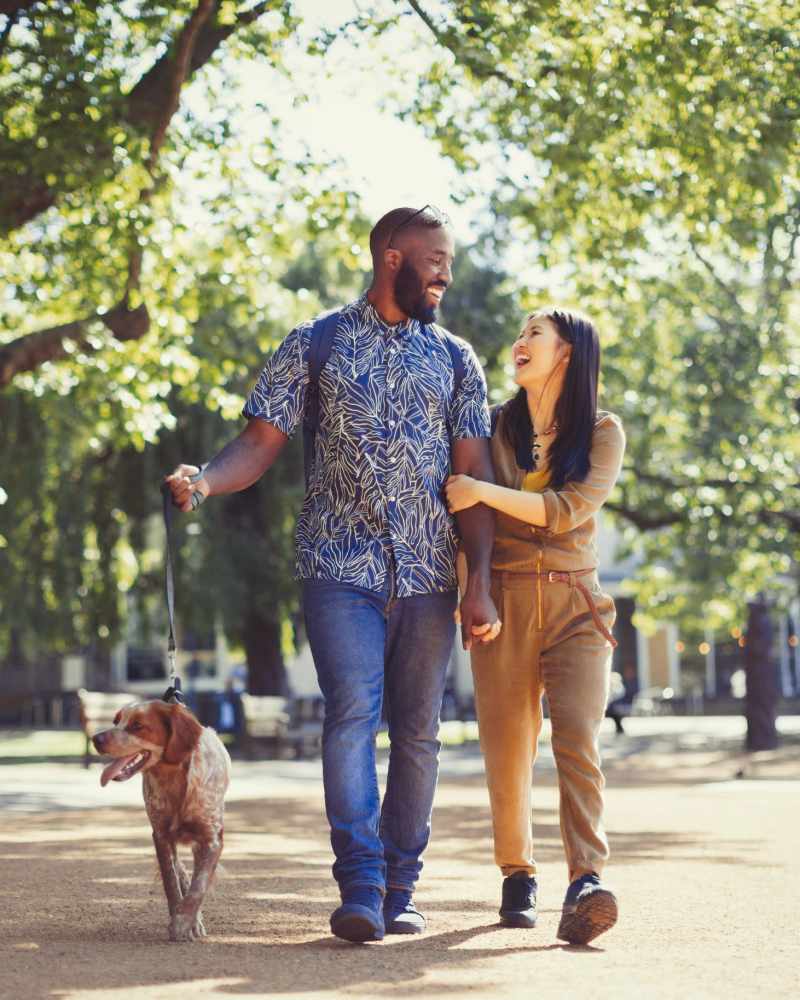 Resident couple walking their pup in a park near The District in Asheville, North Carolina