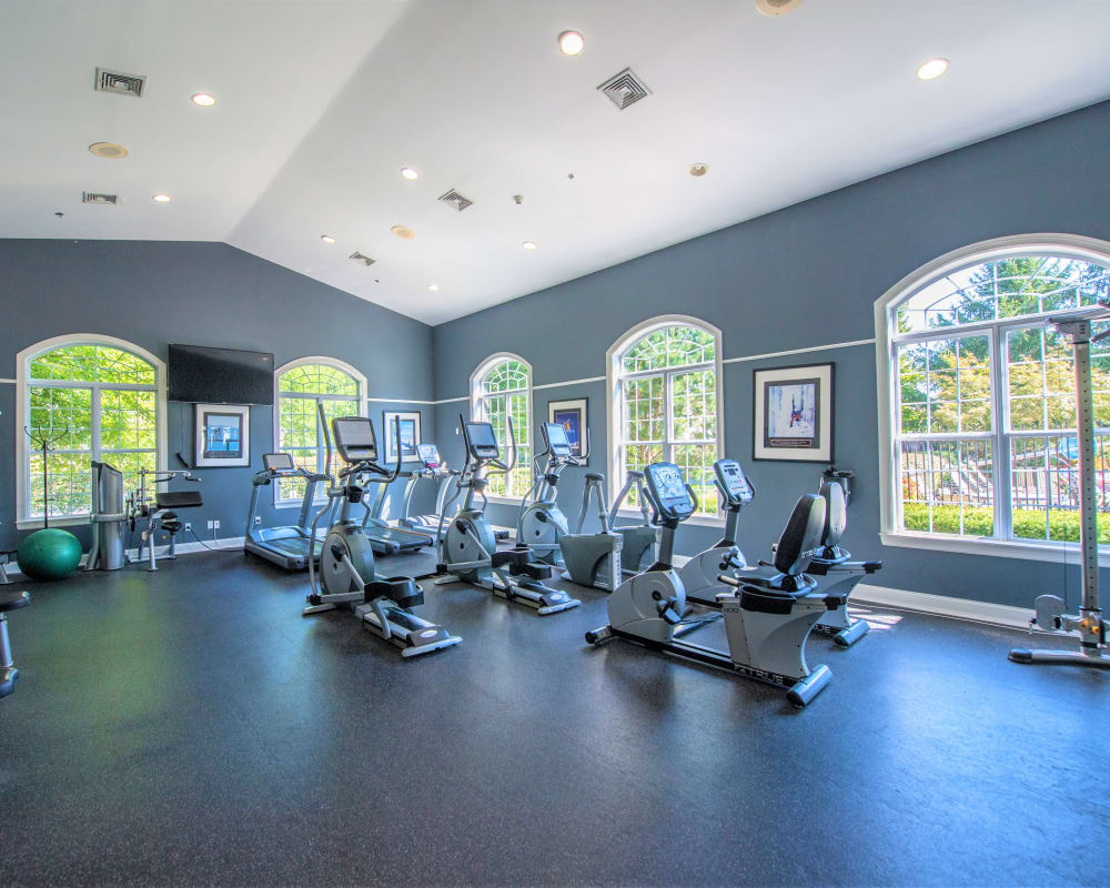 Spacious fitness center with large bay windows and ample equipment at Eagle Rock Apartments at Fishkill in Fishkill, New York