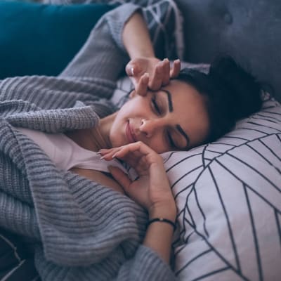 Resident laying in bed in bedroom at 16th Street in Yuma, Arizona