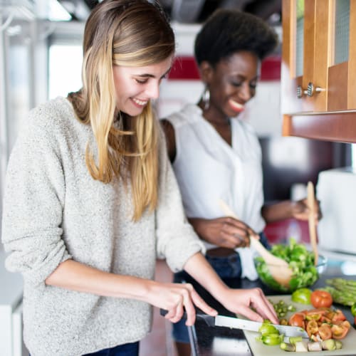 A happy residents cooking in kitchen at Beech St. Knolls in San Diego, California