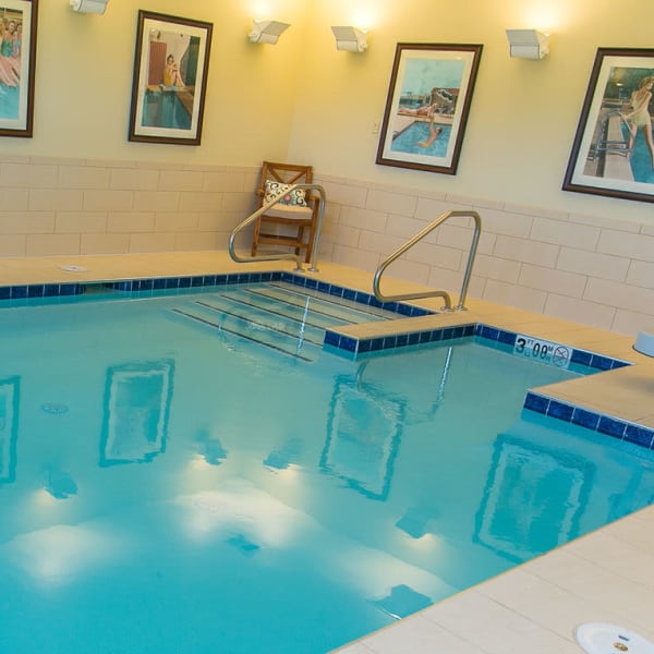 Indoor swimming pool with a view of the outdoors at The Castlewood Senior Living in Nixa, Missouri