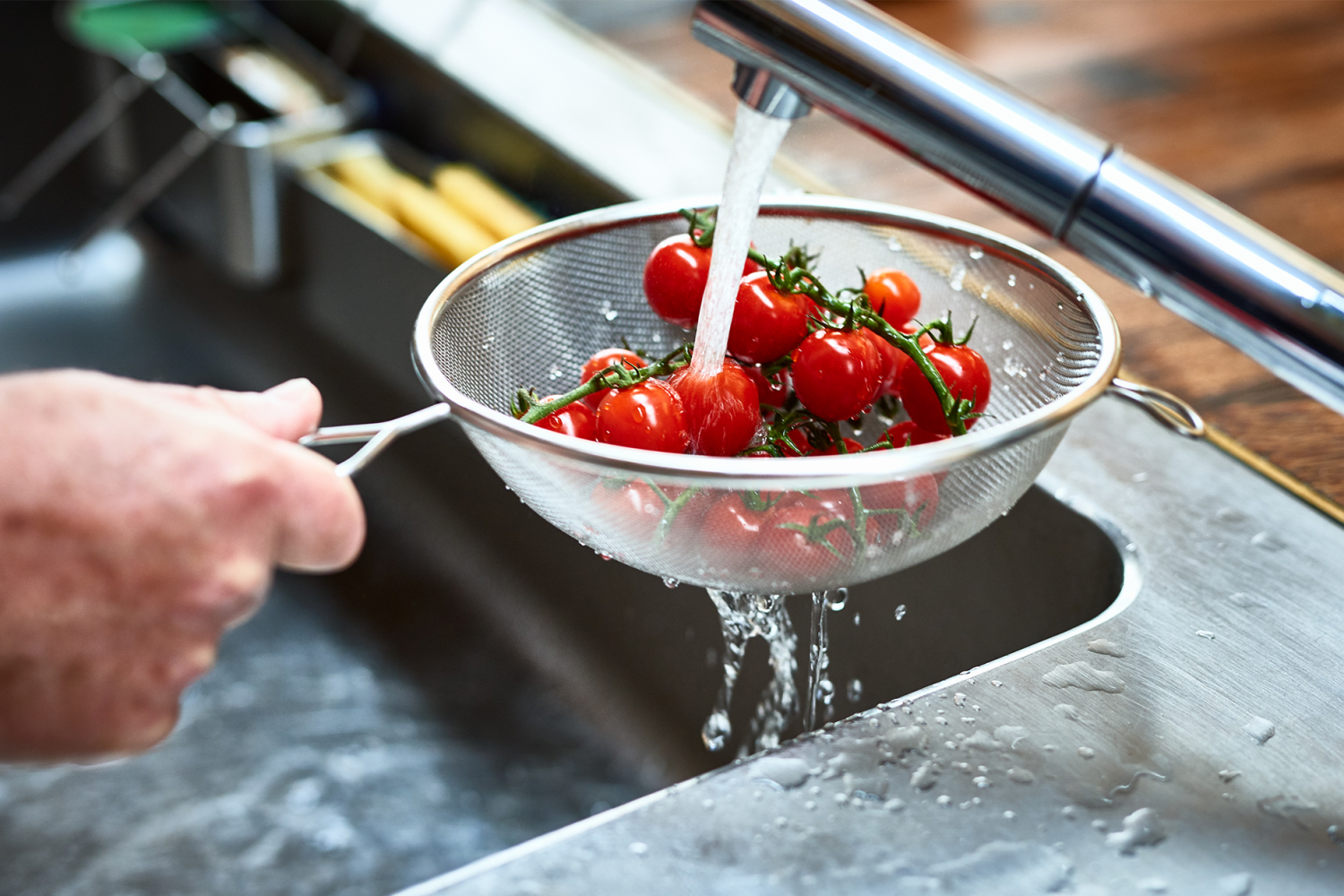 Resident washing tomatoes in the sink at Reserve at the Ballpark in Atlanta, Georgia