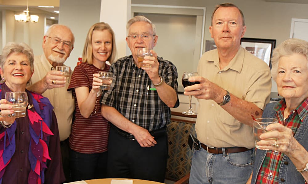 Group of colorfully dressed seniors toasting at MacArthur Hills in Irving, Texas