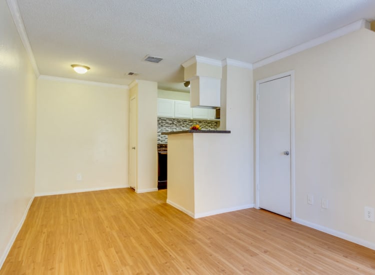 Open-concept layout with hardwood floors in an apartment home at The Establishment at 1800 in Missouri City, Texas