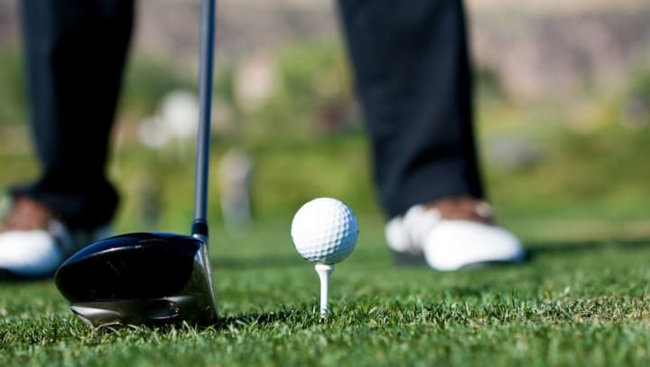 Close up of a person getting ready to drive a golf ball | Golf Courses Around Richmond