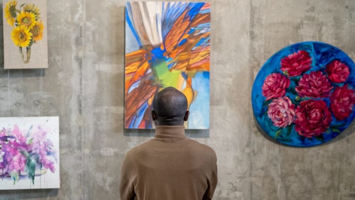 museum visitor looking at displayed artwork | Irvine Fine Arts Center