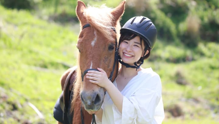 A young woman posing at the camera smiling while hugging a brown horse | Meridian Equestrian Facilities
