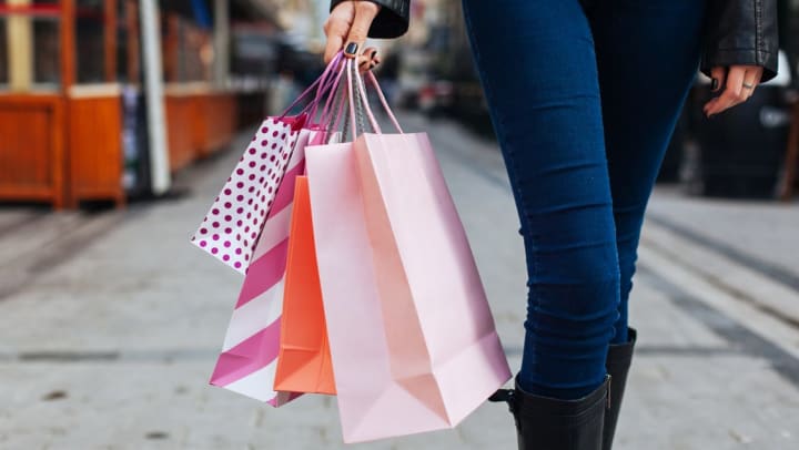 A women from the legs down holding shopping bags in various colors | Gardner Village Near South Jordan