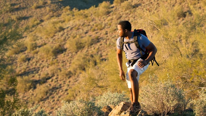 man in the desert on a hike stopping for a break | day hikes in Flagstaff