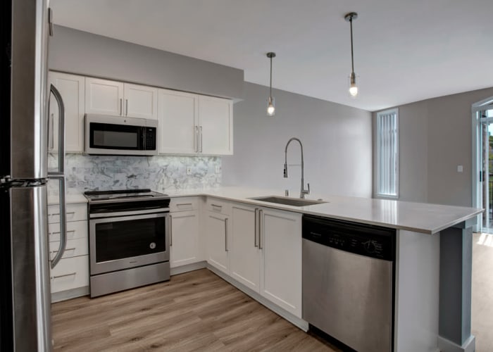 Modern kitchen with quartz countertops and stainless-steel appliances in a model apartment at 700 Broadway in Seattle, Washington