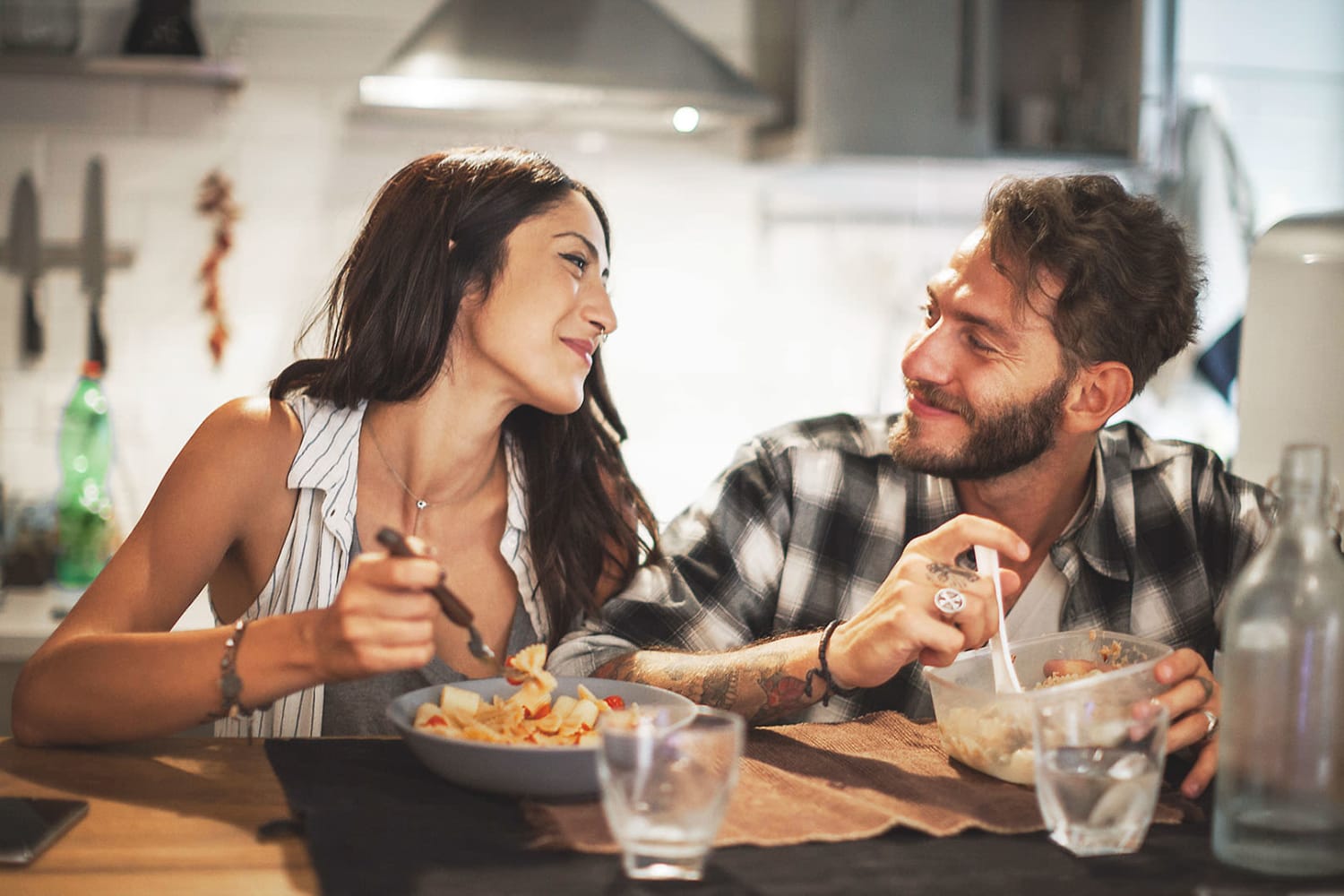 Cute couple enjoying a meal together at home at Waterford Place Apartments in Loveland, Colorado