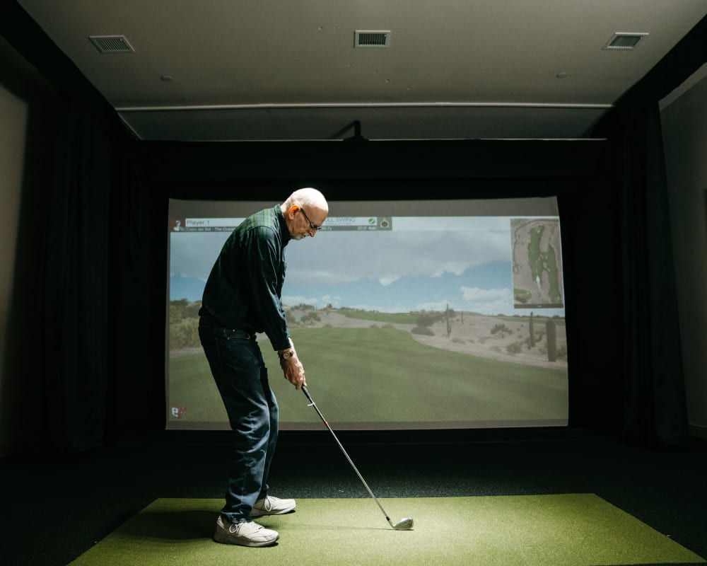 Resident playing virtual golf at The Pillars of Prospect Park in Minneapolis, Minnesota