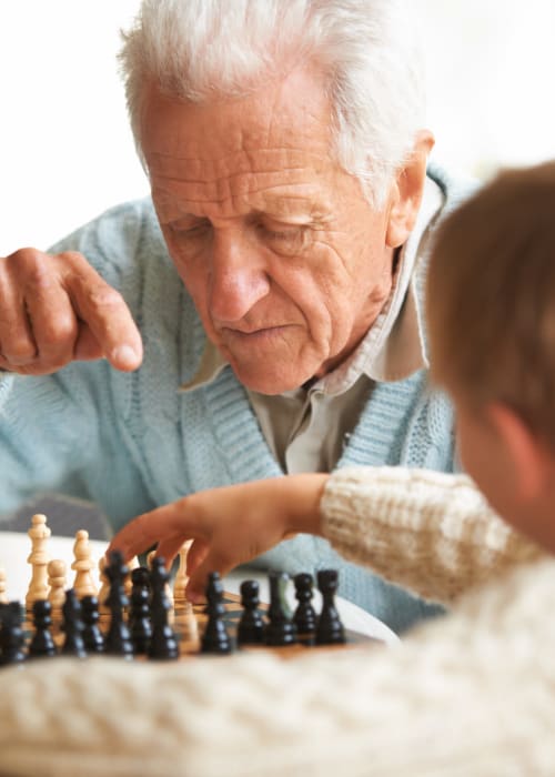 Young boy playing chess with his grandfather at Grand Villa of Clearwater in Clearwater, Florida