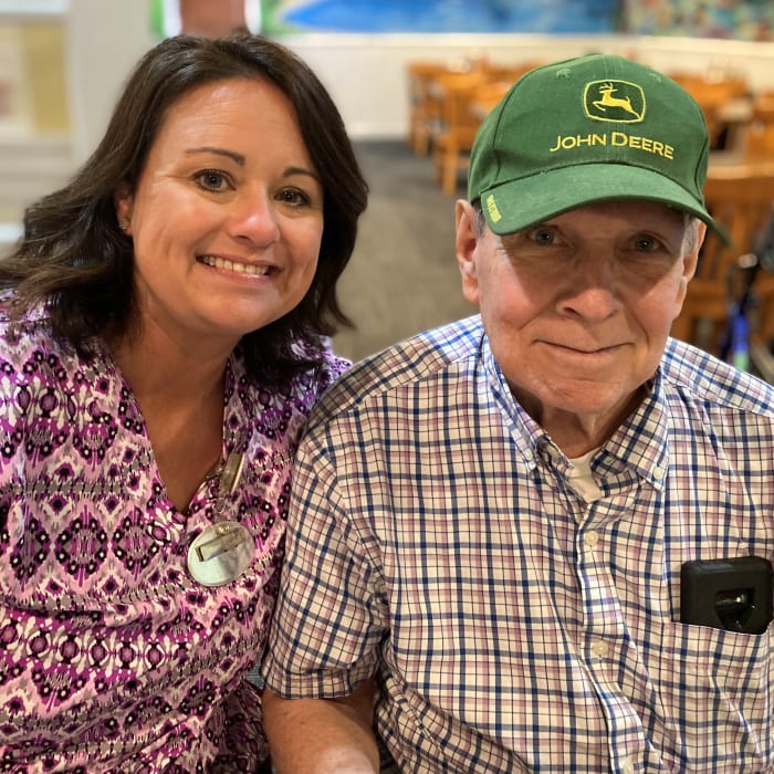 Resident and caretaker smiling and sitting next to each other at The Clinton Presbyterian Community in Clinton, South Carolina