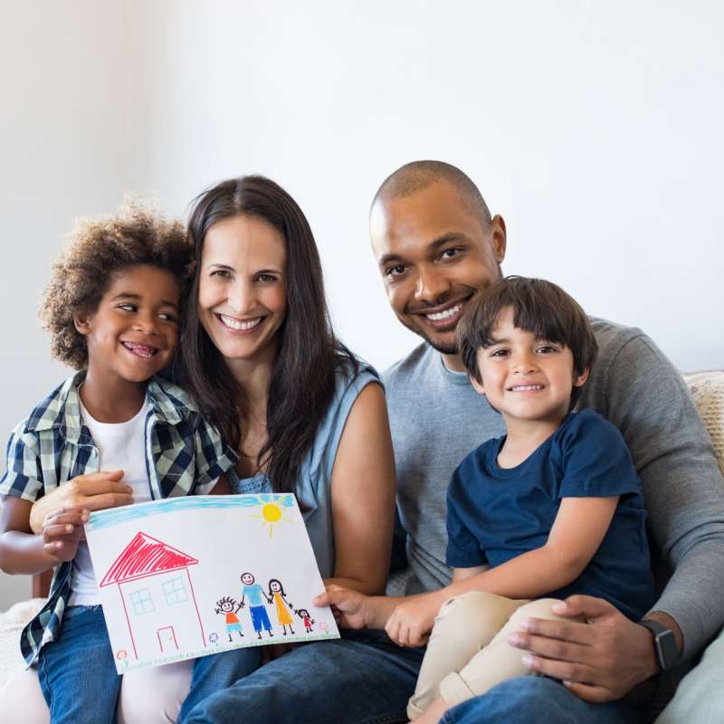 Happy family posing for a photo in the living room at Heron Creek Apartments in Moses Lake, Washington