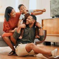 Happy family in the living room at Tapestry on Vaughn in Montgomery, Alabama, 