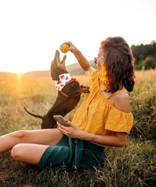 Woman playing with dog in beautiful lanscape at Parish Place in Mount Pleasant, South Carolina