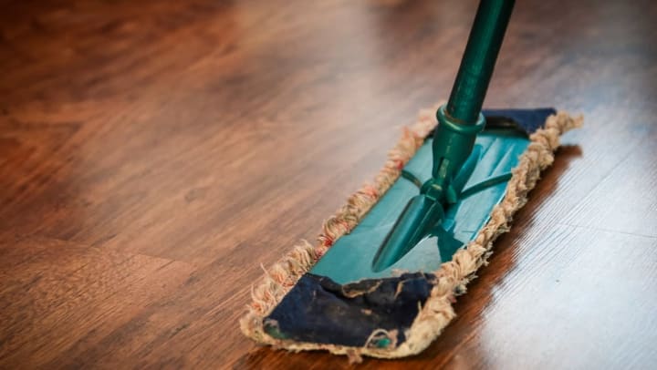 close-up of mop on a wood floor | spring cleaning tips 