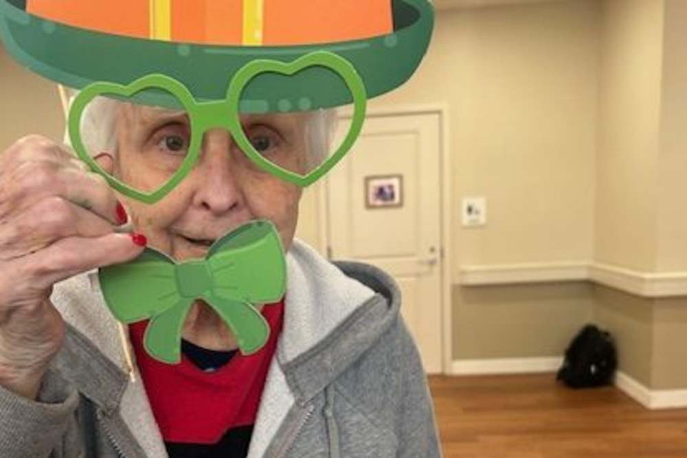 Elderly woman in a green hat and glasses, smiling at The Barclay at Charlottesville in Charlottesville, Virginia.