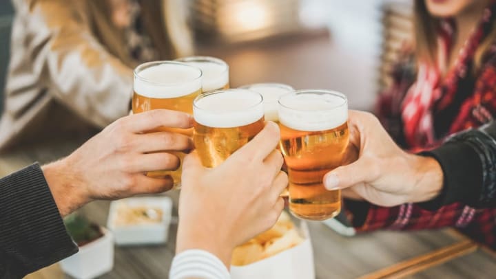 Friends clanking beer glasses at a brewery | breweries in Durango