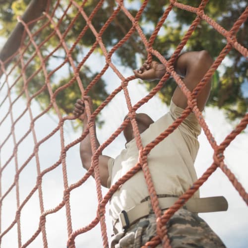 A resident climbing a net near Madigan in Joint Base Lewis McChord, Washington