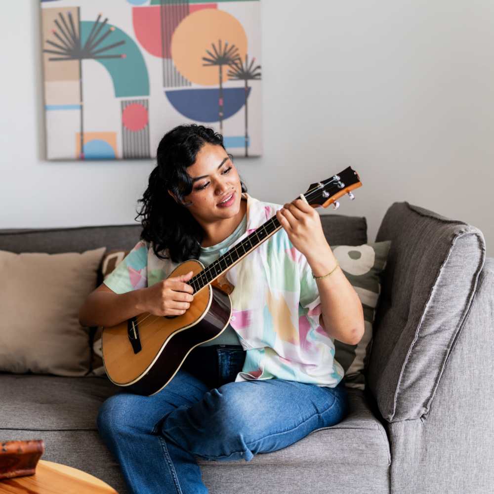 A woman practicing guitar in her apartment home at The Ariel in Charlotte,North Carolina