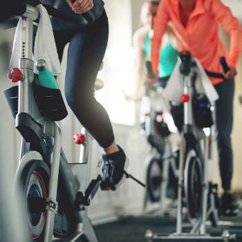 Women exercising on stationary bikes in a bright fitness center at Riverbirch in Ames, Iowa