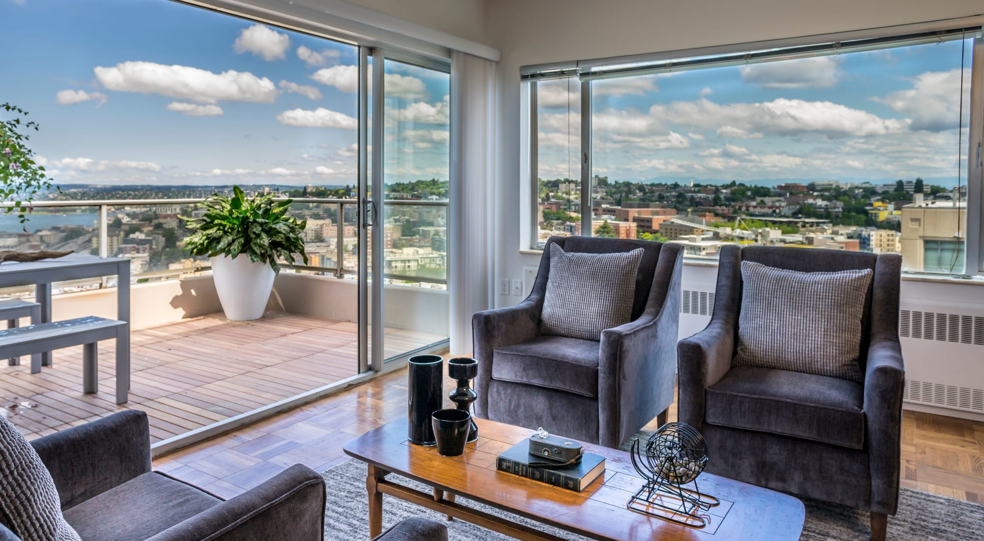 Spacious living room and beautiful view of Seattle through the penthouse floor plan at Panorama Apartments in Seattle, Washington