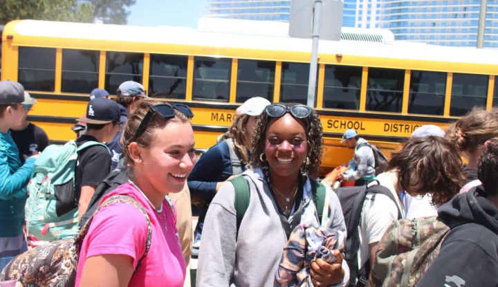 Kids outside of the busses coming into purple camp