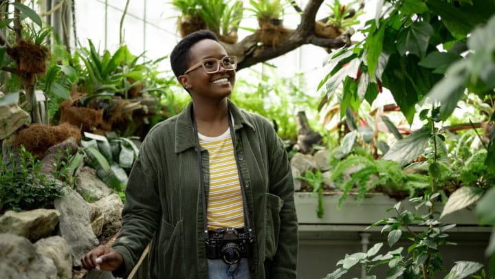 Woman exploring an indoor garden exhibit | Wing Haven