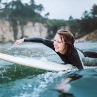 Woman surfing in ocean waves near Cape At Savona Apartments in Cape Coral, Florida