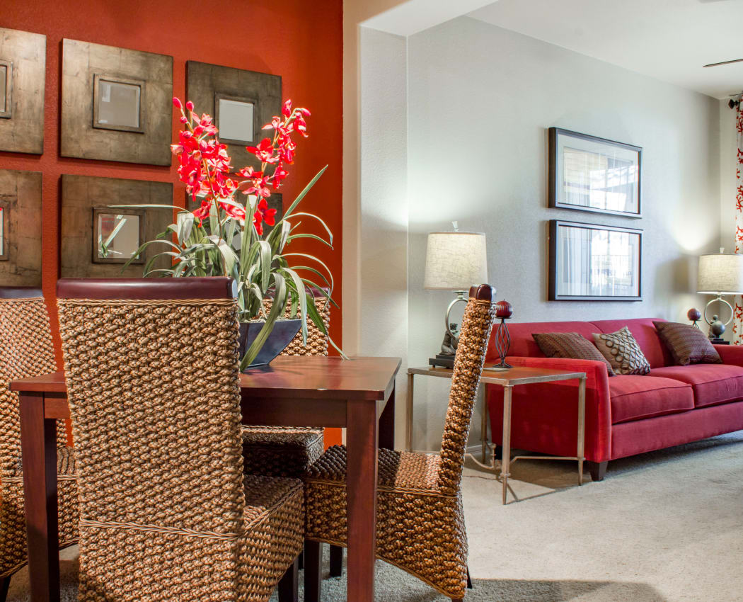 Dining area with accent wall looking into bright and modern living area in model home at The Residences at Stadium in Surprise, AZ