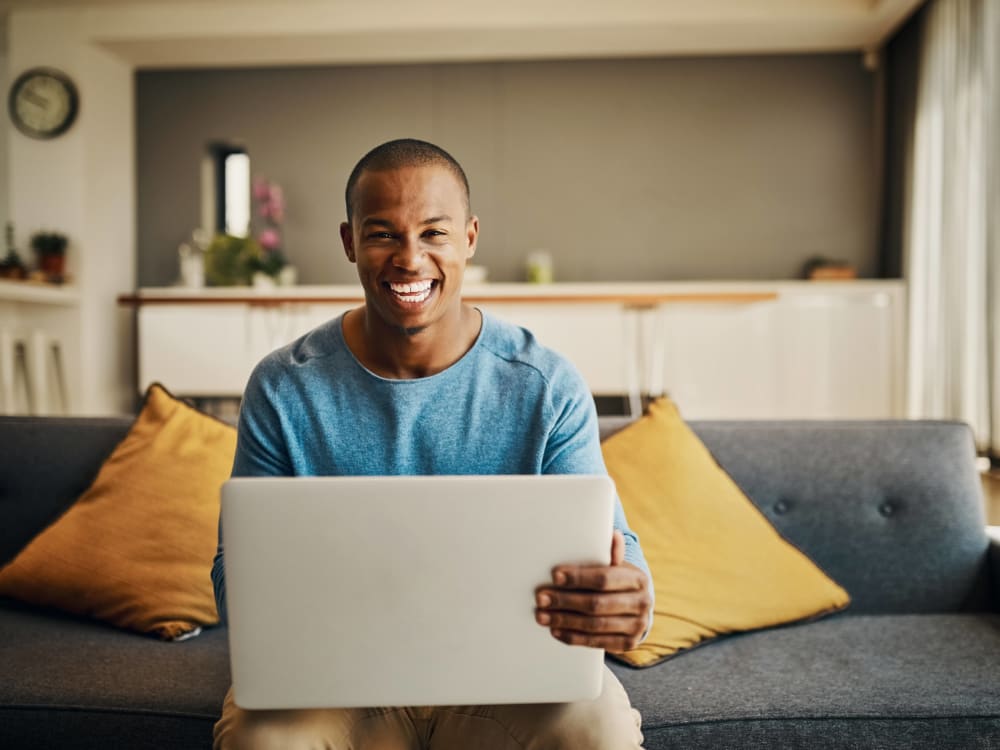 Resident filling out a form on our website on his laptop in his new home at Anson in Burlingame, California